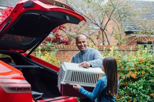 Man and daughter removing personal belongings from their car before shipping